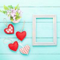 Romantic frame with copy space and accessories on blue wooden background. Top view photo