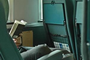 A man passenger is reading while on a train photo