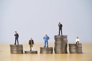 Five Miniature figure in each career standing to different high and low coins stacking for variation of income or salary in each job concept. photo