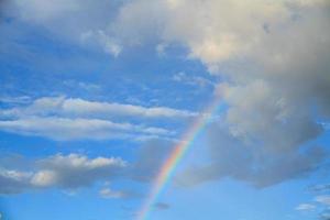 Rainbow, blue sky and white clouds. photo