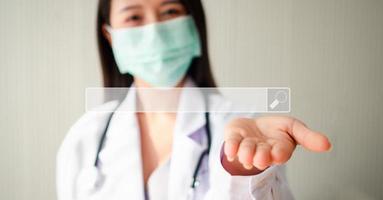 Asian woman doctor open the palm of the hand and on hand have searching browsing internet bar, Concept of Searching Browsing Internet Data Information Networking for medical and healthcare photo