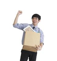 An Asian man stands rejoicing on a white background after being fired, keeping his personal belongings in a carton box. photo