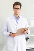 A young male scientist holding a research log in a laboratory photo