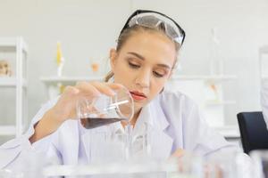 A beautiful female scientist is operating in a science lab with various equipment in the lab. photo