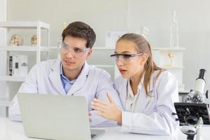 The concept of health care researchers, researchers working in biological science laboratories, young research scientists and male supervisors photo