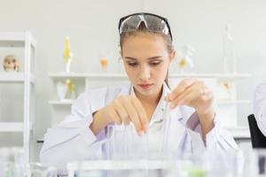 A beautiful female scientist is operating in a science lab with various equipment in the lab. photo