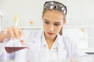 A beautiful female scientist is operating in a science lab with various equipment in the lab. photo