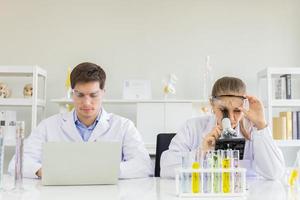 concept of a healthcare researcher, a researcher working in a life science lab, a young research scientist and a male supervisor preparing and analyzing microscopic slides in a research laboratory photo