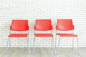 Red plastic chairs are available to allow applicants to sit and wait for a job interview. photo