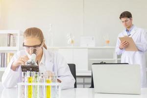 concept of a healthcare researcher, a researcher working in a life science lab, a young research scientist and a male supervisor preparing and analyzing microscopic slides in a research laboratory photo