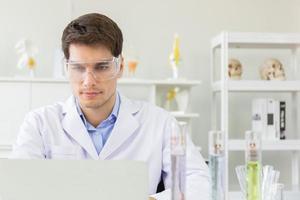 The concept of health care researchers working in biological science laboratories The young male research scientist is preparing and analyzing a slide to find information in a notebook. photo