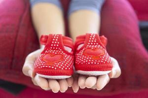 The baby's shoes in the palm of her mother's palm. photo