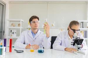 científicos masculinos y femeninos que trabajan en un laboratorio de ciencias con varios equipos en el laboratorio. foto