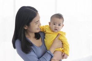 An Asian mother carries her baby with love and care. photo