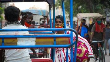 dirección de guía del conductor de rishhaw en delhi india con máscara debido a corona foto