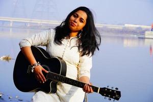 Young woman playing acoustic guitar photo