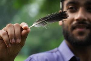 a boy with feather playing with feather photo