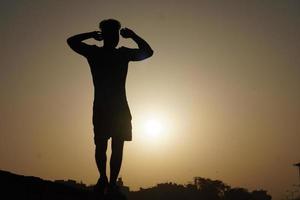 silhouette image of man with sun felling free - motivational concept photo