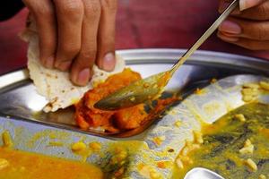 closeup shot of spoon Person is eating food in local Indian shop photo