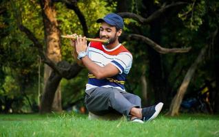 man playing flute in beautiful background photo