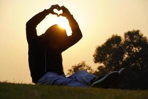 chico dando forma de símbolo de corazón con las manos. foto