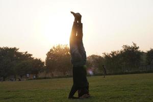 chico haciendo yoga en el parque foto