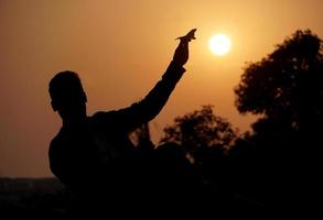 silhouette image of a boy with plane photo