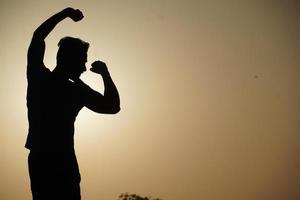 silhouette image of man with sun felling free - motivational concept photo