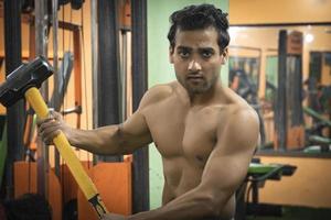 Young man with hammer gym tyre workout healthy man images in gym photo