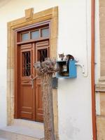 A cat sits on the electricity meter box next to the brown door of a traditional house in old Nicosia, Cyprus photo