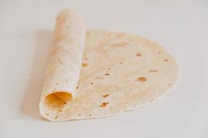 Thin pita bread on a white wooden table background photo