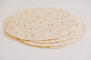 Thin pita bread on a white wooden table background photo