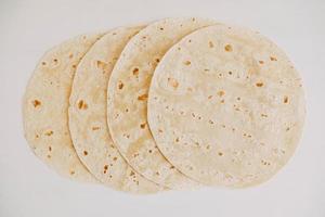 Thin pita bread on a white wooden table background photo