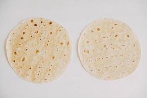 Thin pita bread on a white wooden table background photo