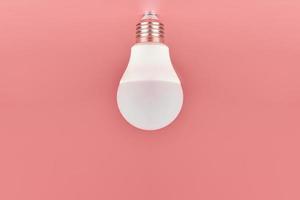 Energy saving light bulb, copy space, pink background. Minimal idea concept. photo