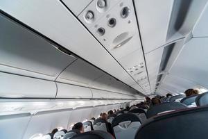 panel de control del aire acondicionado del avión sobre los asientos. aire viciado en la cabina del avión con gente. Nueva aerolínea de bajo coste. foto