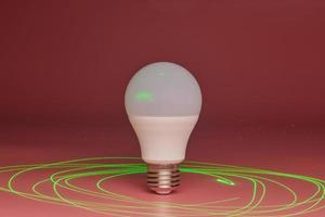 Energy saving light bulb, green laser beam around, copy space. Minimal idea concept. photo