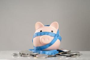Piggy bank and coin on the rope wrapped, debt concept photo