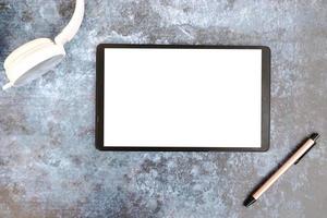 Top view of minimal workplace with digital tablet, smart phone, keyboard and paper on white office desk. photo