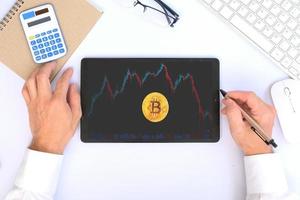 Hand using tablet and analysing banking and investment growth graph to develop smart financial decision for business plan strategy, and analysing forex trading grap photo