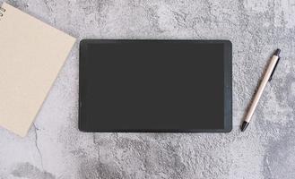 Top view of minimal workplace with digital tablet, smart phone, keyboard and paper on white office desk. photo