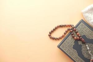 Holy book Quran and rosary on table, close up.