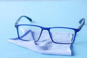 blue color eyeglass and cleaning cloths on table photo