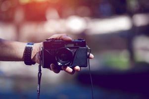Hand and camera of the photographer Travel in the mountains and nature Concept photographer