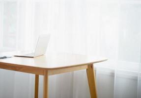 escritorio y una hermosa computadora hay una luz que brilla a través de la ventana por la mañana - imagen foto