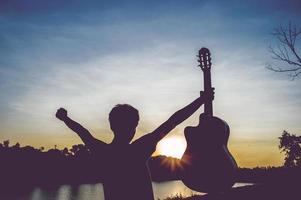 Silhouette of a guitarist in the shadows at sunset light, silhouette concept. photo