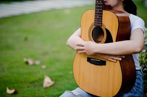 la mujer toca la guitarra alegremente. lindo, brillante, feliz de tocar música que ama los conceptos musicales foto