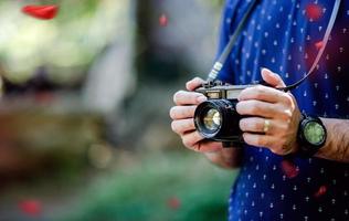 Hand and camera of the photographer Travel in the mountains and nature Concept photographer photo