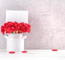 Fotografía de diseño de deseos de cajas de regalo hechas a mano para el día de las madres: hermosos claveles florecientes en jarrón aislados en gris, mesa de fondo de madera, primer plano, espacio para copiar, maqueta foto