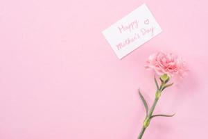 Top view, flat lay, mock up, copy space, handwritten greeting card template isolated with pale pink background, idea concept of thanks, wishes, craft carnations bouquet photo